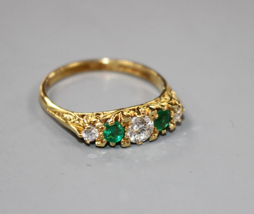 A modern Victorian style 18ct gold, two stone emerald and three stone diamond set half hoop ring,